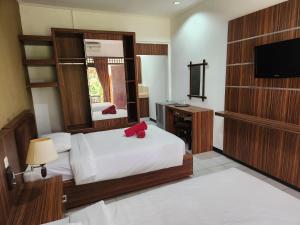 沙努尔罗摩衍那酒店的酒店客房,配有床和电视