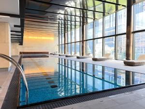 墨尔本Rest SkyHigh Melbourne Qtr Collection的一座大型游泳池,位于一座带窗户的建筑内