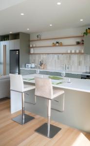 拉格伦Coastal Living in Comfort的厨房配有两把白色椅子和台面