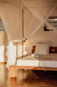 AnjramarangoBelamandy Lodge的卧室配有带蚊帐的床。