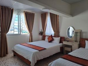 大叻大叻蒂布旅馆的酒店客房,设有两张床和镜子