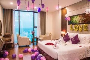 岘港Rosamia Da Nang Hotel的卧室配有一张带紫色气球的床,位于地板上