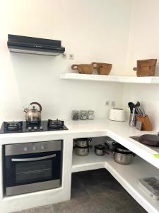 吉利阿尔Cabana的厨房配有炉灶和带锅碗瓢盆的架子。