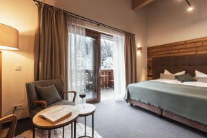 萨尔巴赫Mulk Hotel - Joker Card Partner的酒店客房带一张床、一张桌子和椅子