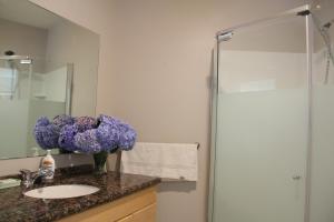 萨里Ocean Park B&B的浴室配有水槽和紫色花瓶