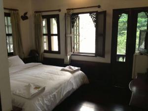 琅勃拉邦坎空美景旅馆的卧室配有白色的床和窗户。