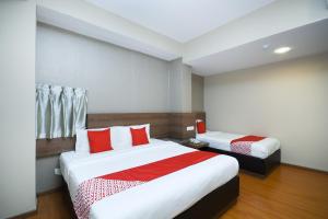 米里Super OYO 977 Hong Kong Suites的酒店客房 - 带两张带红色枕头的床