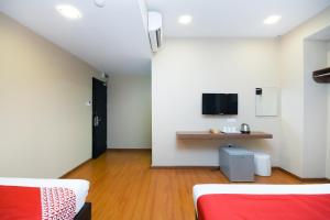 米里Super OYO 977 Hong Kong Suites的一间设有两张床和一张桌子的房间