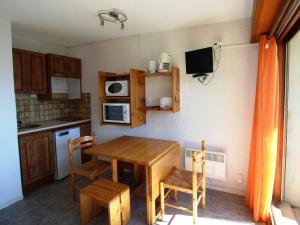 奥瑞斯Appartement Auris, 1 pièce, 3 personnes - FR-1-297-35的一个带木桌和椅子的小厨房