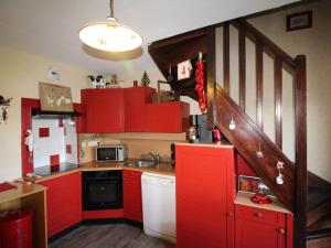 奥瑞斯Appartement Auris, 2 pièces, 6 personnes - FR-1-297-66的一间设有红色橱柜和楼梯的小厨房