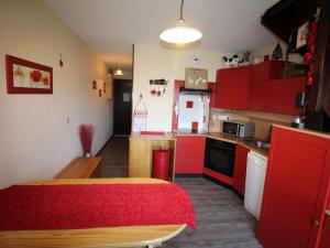 奥瑞斯Appartement Auris, 2 pièces, 6 personnes - FR-1-297-66的一间设有红色橱柜和红色桌子的小厨房