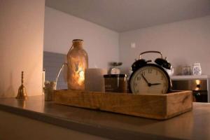 BreitensteinFerienwohnung "Frieda"的桌上的时钟,有玻璃罐和蜡烛