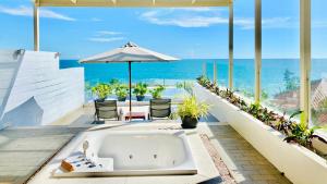 美奈海崖度假酒店的以及位于庭院的浴缸,庭院的背景是大海