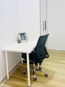 Bandar PenawarUrban Serviced Apartment的办公室里一张带黑椅子的白色书桌