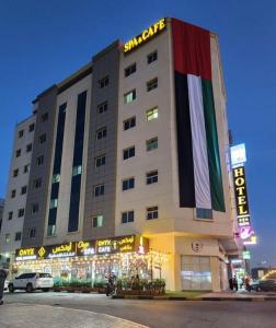 阿吉曼Onyx Hotel Apartments - MAHA HOSPITALITY GROUP的一面有旗帜的大建筑