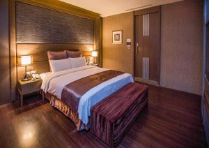 龙潭一加一汽车旅馆的酒店客房设有一张大床和两盏灯。