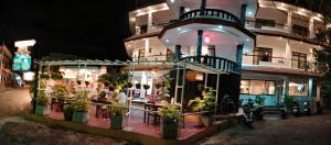 芭东海滩La Capannina Hotel Patong的楼前有盆栽植物的餐厅