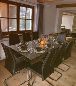 迈尔霍芬EMMA´s Chalet的一张黑色桌子、黑色椅子和用餐室