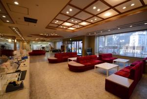 那须盐原市Nasushiobara Ichimantei的大楼内带红色沙发和桌子的大堂