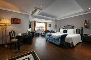 河内Hanoi L'Heritage Hotel & Gym - Spa的卧室配有一张床、一张桌子和椅子
