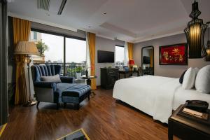 河内Hanoi L'Heritage Hotel & Gym - Spa的一间卧室配有一张床、一把椅子和电视
