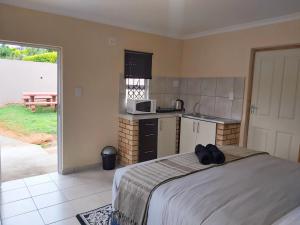InandaEzweni Lodge的一间卧室配有一张床,厨房配有微波炉