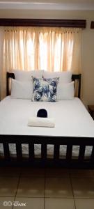 InandaEzweni Lodge的一间卧室配有一张带窗户的床和一张白色的四柱床