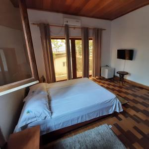 圣多美Ocean View Guesthouse的一间卧室设有一张床和一个大窗户