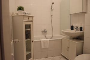 开姆尼茨alexxanders Apartments & Studios的一间带水槽、浴缸和卫生间的浴室