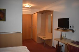 东贝沃恩Hotel Alte Post Ostbevern的客房设有一张床、一张书桌和电视