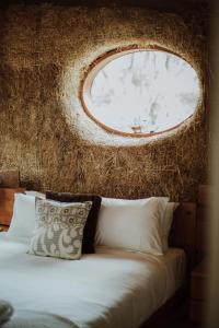 South BrunyThree Little Pigs Escape - MAIN HOUSE ONLY的一间卧室配有一张带圆形窗户的床