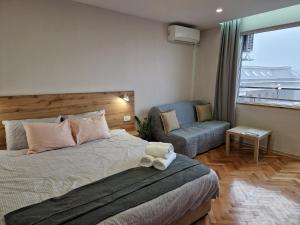 鲁塞Malavi A5 top center apartment Ruse的卧室配有床、椅子和窗户。