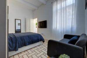 弗洛里亚纳Idyllic Apartment close to Valletta的一间卧室配有一张床、一张沙发和一台电视