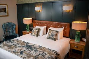 特伦特河畔伯顿Riverside Hotel by Chef & Brewer Collection的一间卧室配有一张带两盏灯和一把椅子的床。