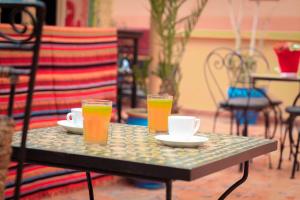 马拉喀什多加住宿加早餐旅馆的一张桌子,上面放着两杯和两杯橙汁