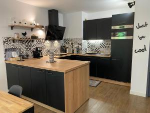 贝尔热拉克Le Parc的厨房配有黑色橱柜和木制台面