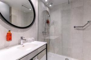 哈瑟尔特哈瑟尔特假日酒店的浴室配有盥洗盆和带镜子的淋浴