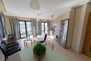 埃斯帕桑特港Apartagal-Apartamentos Espasante的厨房以及带桌椅的起居室。