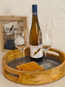 克林根明斯特Urlaub beim Winzer的装有一瓶葡萄酒和两杯酒的木托盘