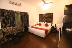 新德里Hotel Capitol Hills - Greater Kailash Delhi的酒店客房,配有床和沙发