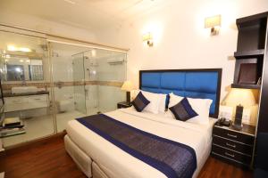 新德里Hotel Capitol Hills - Greater Kailash Delhi的一间卧室设有一张大床和淋浴