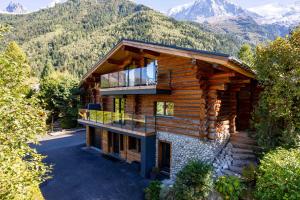 夏蒙尼-勃朗峰Chalet des Cimes - Chamonix All Year的享有小木屋的空中景致,以山脉为背景