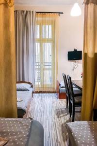 罗兹Apartaments Piotrkowska 101的客房设有两张床、一张桌子和一扇窗户。