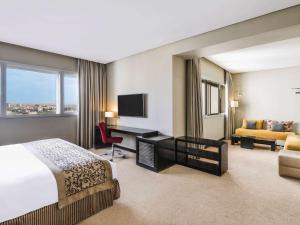 卡萨布兰卡卡萨布兰卡瑞享酒店的酒店客房配有一张床、一张书桌和一张沙发。