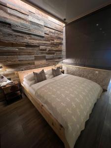 瓦尔德阿尔贝格Alpenburg Bergparadies Apartments的一间卧室设有一张带木墙的大床