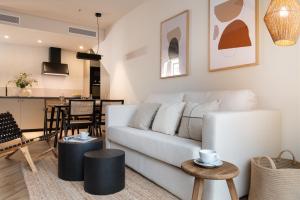 塞维利亚Magno Apartments Robles with Bath Tub and Private Parking的客厅配有白色的沙发和桌子