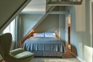 汉堡Landhaus Jenischpark的阁楼卧室配有床和椅子