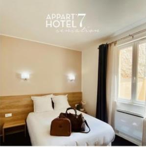 布吉瓦尔Appart' hôtel 7 sensation的酒店客房,配有一张带钱包的床