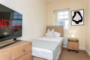 莱兰The Fusiliers的一间卧室配有一张床和一台平面电视