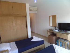 达哈布Red Sea Relax Hotel的酒店客房配有一张床和一张书桌及一台电视